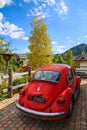 COLFOSCO, ITALY - SEP 26, 2013: Vintage red Volkswagen VW Beetle car parked in front of a house in alpine village Colfosco, Royalty Free Stock Photo