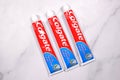 Colgate tubes for oral hygiene on marble white background. Colgate brand products are made by Colgate-Palmolive company