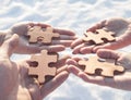 Collaborate four hands trying to connect a puzzle piece with a sunset background. Royalty Free Stock Photo