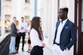 Collaborating mixed race business colleagues discussing future plans in front of business team Royalty Free Stock Photo