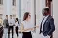 Collaborating mixed race business colleagues discussing future plans in front of business team Royalty Free Stock Photo