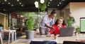 Collaborating two women colleagues sharing ideas at open plan office, with laptop and coffee cups Royalty Free Stock Photo