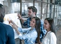 Collaboration is a key to best results. Group of young modern people in smart casual wear planning business strategy while young Royalty Free Stock Photo