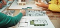 Collaborative Design Session for Modern Architecture with Detailed Plans and Samples on Table in Bright Workspace SACTR Royalty Free Stock Photo