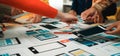 Collaborative Team Designing Mobile App Interfaces with Prototypes and Wireframes on a Bright Table in a Creative Royalty Free Stock Photo
