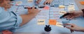 Collaborative Team Meeting with Marketing Strategy Flowchart on Table Surrounded by Colorful Sticky Notes and Markers in Royalty Free Stock Photo