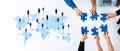 Collaborative Teamwork Concept with Hands Assembling Puzzle Pieces Over World Map Representing Global Connection and Royalty Free Stock Photo