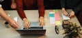 Collaborative Workspace with Laptop, Colorful Sticky Notes and Hands of Diverse Individuals Engaged in a Creative Royalty Free Stock Photo