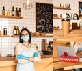 Collage of cafe owner in medical mask with crossed arms near tables with paper cup of coffee, laptop and card