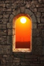 Stone war tower window with sunset landscape