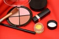 Collage of cosmetics, makeup material on red fabric