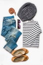 Collage of female clothing set. Ripped jeans, striped blouse, brown high heels shoes and accessories over white wood background.