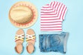 Collage of girl woman summer clothes on a blue background, hat, shorts, t-shirt, sandals. Flat lay, top view