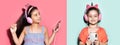 Collage portraits of two happy children`s girls, using smartphone and headphones. Studio backgrounds of pastel pink and blue. Royalty Free Stock Photo