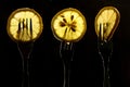 Collage of three slices of lemons on the fork on dark black background. silhouette of a fork in the back light. Drops of juice