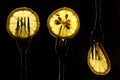 Collage of three slices of lemons on the fork on dark black background. silhouette of a fork in the back light. Drops of juice