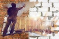 Collage from two images - Wall made from foamed concrete blocks, red bricks and worker in construction site. Concept of Royalty Free Stock Photo