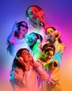 Collage. Young beautiful girls in casual clothes listening to music in headphones over multicolored background in neon Royalty Free Stock Photo