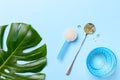 Collagen powder and capsules vitamin d-3 on a blue background with a beautiful green leaf. Royalty Free Stock Photo