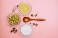 Collagen powder or yellow clay with dried flowers and sea salt on pink pastel background with wooden spoon. Flat lay Royalty Free Stock Photo