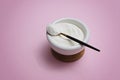 Collagen protein powder in a bowl with a modern spoon on pink background
