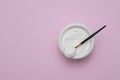 Collagen protein powder in a bowl with a modern spoon on pink background