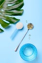 Collagen protein powder in a measuring spoon, vitamin capsules, glass of pure water on a blue background. Royalty Free Stock Photo