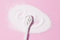 Collagen spoon on a pink background. Top view