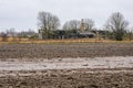 Collapsed country house on the edge of a plowed field