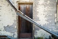 Collapsed gutter in front of a door to an abandoned building Royalty Free Stock Photo