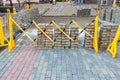 Collapsible plastic fence blocks block a passage. Repair of pedestrian zone, replacement of paving stones