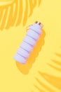 Collapsible reusable lilac water bottle on yellow background. Sustainability, eco-friendly lifestyle