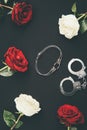 Collar and handcuffs with rose flowers isolated on black Royalty Free Stock Photo