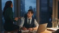 Colleague bringing tea man executive manager working at office desk late evening Royalty Free Stock Photo