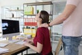 Colleague does neck massage to woman in company office