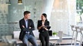 Colleague partners leaning on the desk and talking in the office