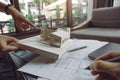 The colleague team of architects discussing and pointing at architecture model with shop drawing paper and laptop Royalty Free Stock Photo