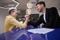 Colleagues arm-wrestling for project supervision in the office