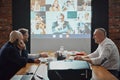 Colleagues, business people meeting with employees via online video call in conference room for project discussion Royalty Free Stock Photo
