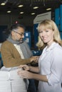 Colleagues With Calculator Checking Newspaper In Factory Royalty Free Stock Photo