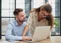 Colleagues check documents using a laptop. A man and a woman are sitting together looking at a laptop. business concept Royalty Free Stock Photo