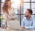 Colleagues check documents using a laptop. A man and a woman are sitting together looking at a laptop. business concept Royalty Free Stock Photo