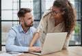 Colleagues check documents using a laptop. A man and a woman are sitting together looking at a laptop. business concept Royalty Free Stock Photo