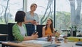 Colleagues group coffee break at workspace. Young business team talking calmly Royalty Free Stock Photo