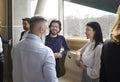 Cheerful business people enjoy socializing and discussing during work break in office. Royalty Free Stock Photo