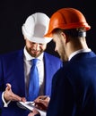 Colleagues in helmets discuss building plans. Royalty Free Stock Photo