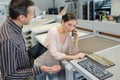 Colleagues holding digital tablet and mobile phone in creative office