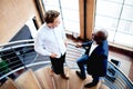 Colleagues interacting at work standing on staircase