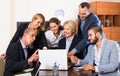 Colleagues looking at laptop and smiling