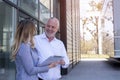 Colleagues looking at note board and discussing a project in front of the office building Royalty Free Stock Photo